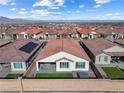 Aerial view of a well-maintained backyard, including a patio, artificial grass and hot tub at 6557 Corsari Ridge St, Las Vegas, NV 89166
