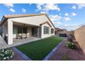 Inviting backyard with a covered patio, artificial grass, and a relaxing hot tub at 6557 Corsari Ridge St, Las Vegas, NV 89166
