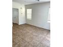 Bright living area with tiled floors, white walls, and natural light from two windows at 7351 San Pablin St, Las Vegas, NV 89139