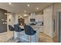 Bright kitchen featuring white cabinets, stainless steel appliances, granite countertops, and tile flooring at 7938 Jessamy St, North Las Vegas, NV 89084