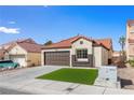 Single-story home featuring desert landscaping, a tile roof, and an attached two-car garage at 7957 Lovely Pine Pl, Las Vegas, NV 89143