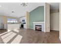 Open concept living room and kitchen area with modern lighting and fireplace at 7957 Lovely Pine Pl, Las Vegas, NV 89143
