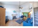 Bright living room with vaulted ceilings, a fireplace, and wood laminate floors at 7985 Simone Ave, Las Vegas, NV 89147