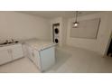 Bright kitchen featuring white cabinetry, granite counters, and laundry machines at 833 Hedge Way # 2, Las Vegas, NV 89110