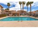 Community pool surrounded by palm trees and lounge chairs at 8450 Alta Dr # 136, Las Vegas, NV 89145
