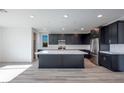 Open kitchen featuring a large center island, stainless steel appliances, and sleek, dark cabinetry at 1321 Crimson Sunbird Ave, North Las Vegas, NV 89084