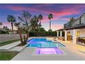 Backyard pool area featuring a luxurious pool and spa, landscaped yard, and outdoor dining space at 2425 Greens Ave, Henderson, NV 89014