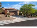 View of the front yard of the home and long driveway leading to the attached two car garage at 2554 Braehead Ln, Henderson, NV 89044