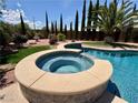 Close-up of the inviting in-ground spa with clear blue water and lush landscaping at 2554 Braehead Ln, Henderson, NV 89044
