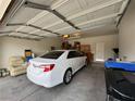 Spacious two-car garage with ample storage space, currently housing a sedan and other household items at 2571 Swans Chance Ave, Henderson, NV 89052