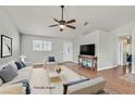 Bright living room with hardwood floors, ceiling fan, and a neutral color palette at 2805 El Cubano Ct, North Las Vegas, NV 89030