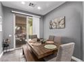 Cozy dining area with wood table, bench seating and sliding glass door leading to outdoor space at 3005 Dotted Wren Ave, North Las Vegas, NV 89084