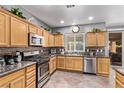Kitchen with stainless steel appliances, wood cabinets, and granite countertops at 3005 Dotted Wren Ave, North Las Vegas, NV 89084