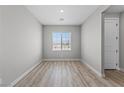 Bright bedroom featuring wood-look flooring, base molding, and a window with a view at 3233 Walker River St, North Las Vegas, NV 89032