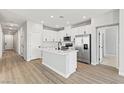 Modern kitchen features white cabinets, stainless steel appliances, and a central island with a white countertop at 3237 Walker River St, North Las Vegas, NV 89032