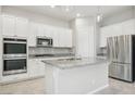 Modern kitchen featuring white cabinetry, stainless steel appliances, and a spacious granite countertop island at 354 Spotted Dove St, Las Vegas, NV 89138