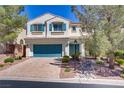 Charming two-story home with a well-manicured front yard, blue shutters, and a two car garage at 4012 Owlshead Mountain St, Las Vegas, NV 89129