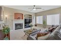 Cozy living room with fireplace, carpeted floors, large windows and comfortable seating at 4012 Owlshead Mountain St, Las Vegas, NV 89129