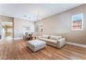 Bright living room featuring hardwood floors, plantation shutters, and a modern neutral-toned couch at 601 Bear Grass St, Las Vegas, NV 89144