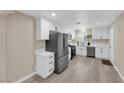 Beautiful kitchen featuring stainless steel appliances, modern white cabinets, and lovely laminate flooring at 608 W Mcdermit St, Las Vegas, NV 89107