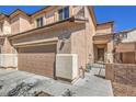 Townhome showcasing a two-car garage, textured exterior, and well-kept landscaping for curb appeal at 632 Twilight Blue Ave, North Las Vegas, NV 89032