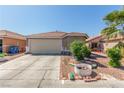 Single-story home with two-car garage, tile roof, xeriscaping, and desert landscaping in the front yard at 6489 Coldwater Bay Dr, Las Vegas, NV 89122