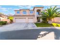 Inviting two-story home with a spacious driveway and a lush green lawn at 695 Orbiter Ln, Las Vegas, NV 89148