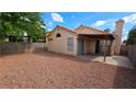Large, private backyard with a covered patio and low-maintenance gravel landscaping surrounded by a block wall at 7053 Magic Moment Ln, Las Vegas, NV 89119