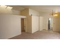 Spacious living room featuring neutral walls, carpet flooring, and a modern chandelier at 7053 Magic Moment Ln, Las Vegas, NV 89119