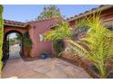 Private courtyard entrance featuring desert landscaping and stonework with an iron gate, offering a tranquil outdoor space at 7204 Royal Melbourne Dr, Las Vegas, NV 89131