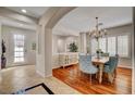 Elegant dining room featuring a wood table, chandelier lighting, and shuttered windows for natural light with hardwood flooring at 7204 Royal Melbourne Dr, Las Vegas, NV 89131
