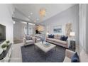 Staged living room with vaulted ceilings, modern lighting and plush furnishings at 7589 Grassy Bank St, Las Vegas, NV 89139