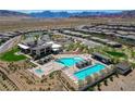 Beautiful aerial view of community pool and clubhouse with desert landscape and mountain backdrop at 897 Woodburn Ln, Las Vegas, NV 89138