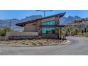 Community entry building with mountain views, modern design, stone accents and desert landscaping at 897 Woodburn Ln, Las Vegas, NV 89138
