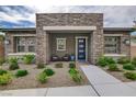Inviting front porch showcasing stone pillars, a blue front door, and a cozy seating area at 897 Woodburn Ln, Las Vegas, NV 89138