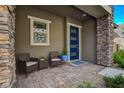 Cozy front porch with outdoor seating, a modern blue door, and stone detailing for added curb appeal at 897 Woodburn Ln, Las Vegas, NV 89138