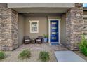 Inviting front porch features stone accents and a cozy seating area, perfect for enjoying quiet moments at 897 Woodburn Ln, Las Vegas, NV 89138