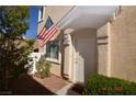Charming front entrance adorned with American flag, manicured shrubs, and a cozy outdoor setting at 9343 Leaping Deer Pl # 103, Las Vegas, NV 89178