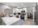 Modern kitchen with white cabinets, stainless steel appliances, and a breakfast bar overlooking the dining area at 9540 Eagle Valley Dr, Las Vegas, NV 89134