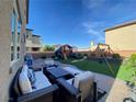 Beautifully landscaped backyard features a playground, swing set, and plenty of patio seating at 10152 Tenaya Meadows St, Las Vegas, NV 89178