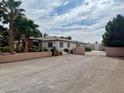 Spacious ranch home showcasing a grand front entrance and driveway with lush landscaping and a secure gate at 10561 Rancho Destino Rd, Las Vegas, NV 89183