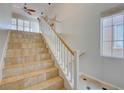 Bright staircase features tile steps, white risers, and wood handrail, bathed in natural light at 11833 Amistoso Ln, Las Vegas, NV 89138