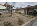 A single-story home with an unkempt front yard with a swing set and rock facade at 1338 Smoke Tree Ave, Las Vegas, NV 89108