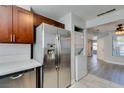 Well-lit kitchen with stainless steel refrigerator, in-unit washer/dryer, wood cabinetry and composite countertop at 1550 Jamielinn Ln # 102, Las Vegas, NV 89110