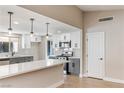 Well-lit kitchen with island seating, stainless appliances, and sleek white and gray cabinetry at 1943 Hallwood Dr, Las Vegas, NV 89119