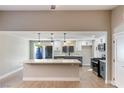 Open concept kitchen boasts a large island, stylish pendant lighting, and modern appliances at 1943 Hallwood Dr, Las Vegas, NV 89119