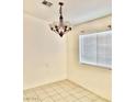 Dining room with a modern chandelier, tile flooring, and a window offering natural lighting at 2050 N Los Feliz St # 114, Las Vegas, NV 89156