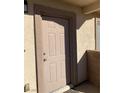 Close up of the front door, displaying the unit number and neutral color, set in stucco with tan trim at 2050 N Los Feliz St # 114, Las Vegas, NV 89156