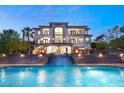 An impressive home exterior showcasing a waterfall feature cascading into a pool, and an elegant facade at 22 Anthem Pointe Ct, Henderson, NV 89052