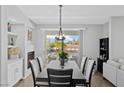 Inviting dining room with modern light fixture, balcony access, and views of the surrounding neighborhood at 2325 Windmill Pkwy # 1124, Henderson, NV 89074